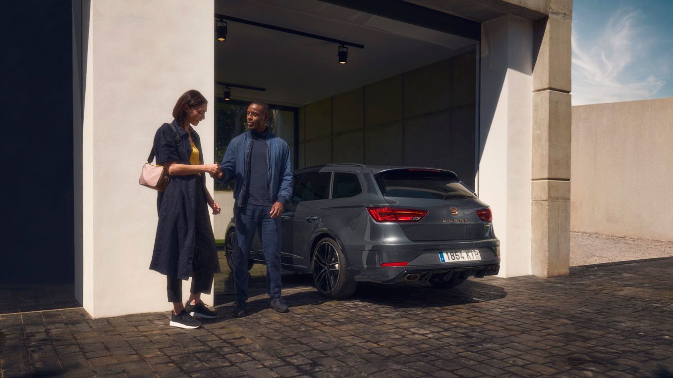 Egy pár egy Seat Cupra mellett