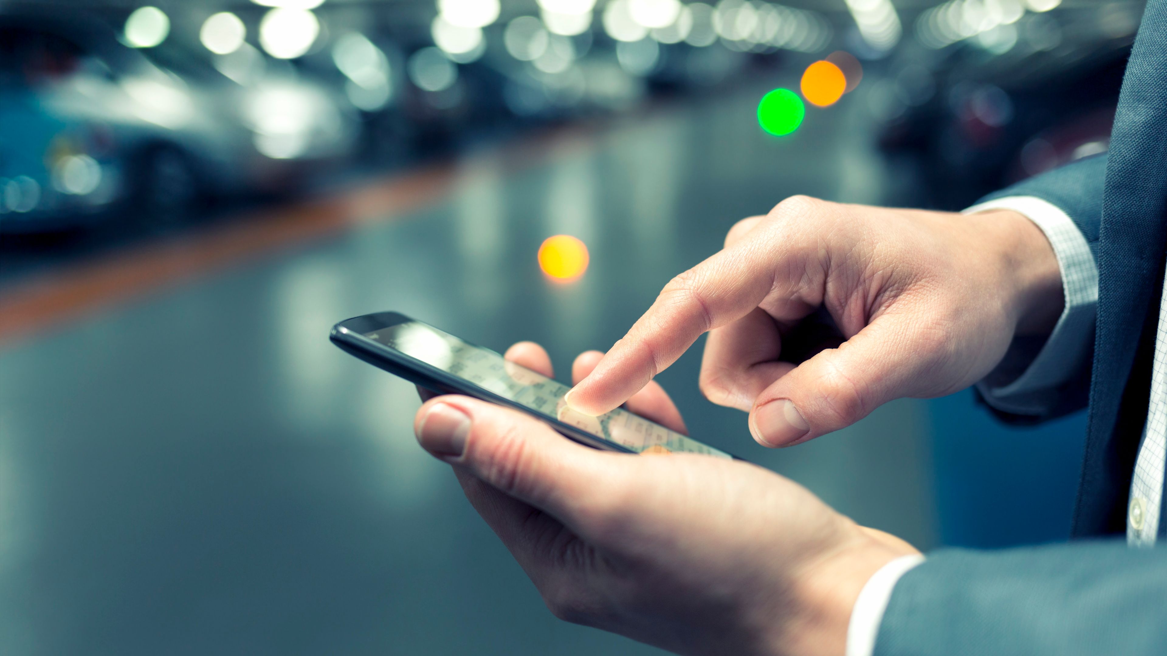 Férfi kéz egy telefon képernyőjén