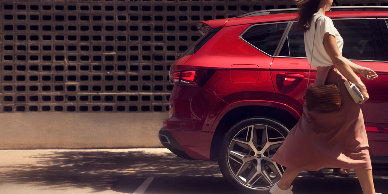 SEAT Ateca mellett sétál egy nő