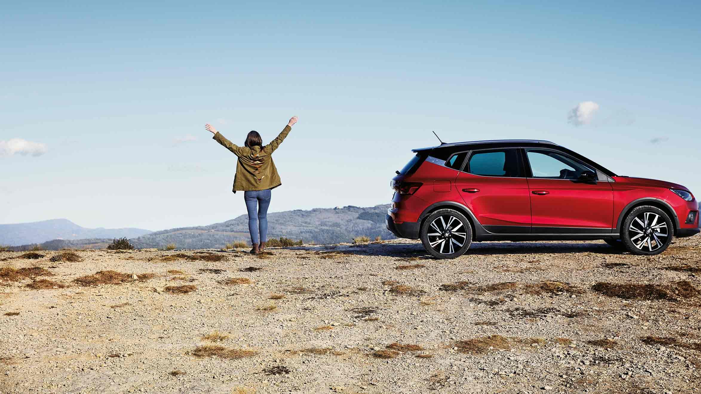 SEAT Arona egy magaslaton, mellette egy nő