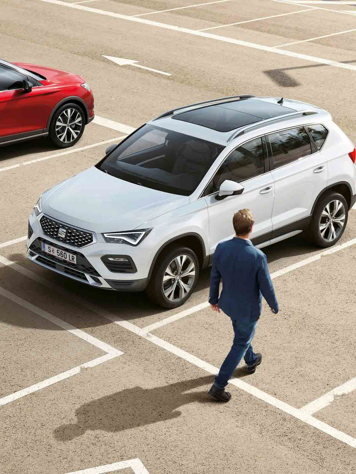 Két SEAT modell egy üres parkolóban és egy férfi 