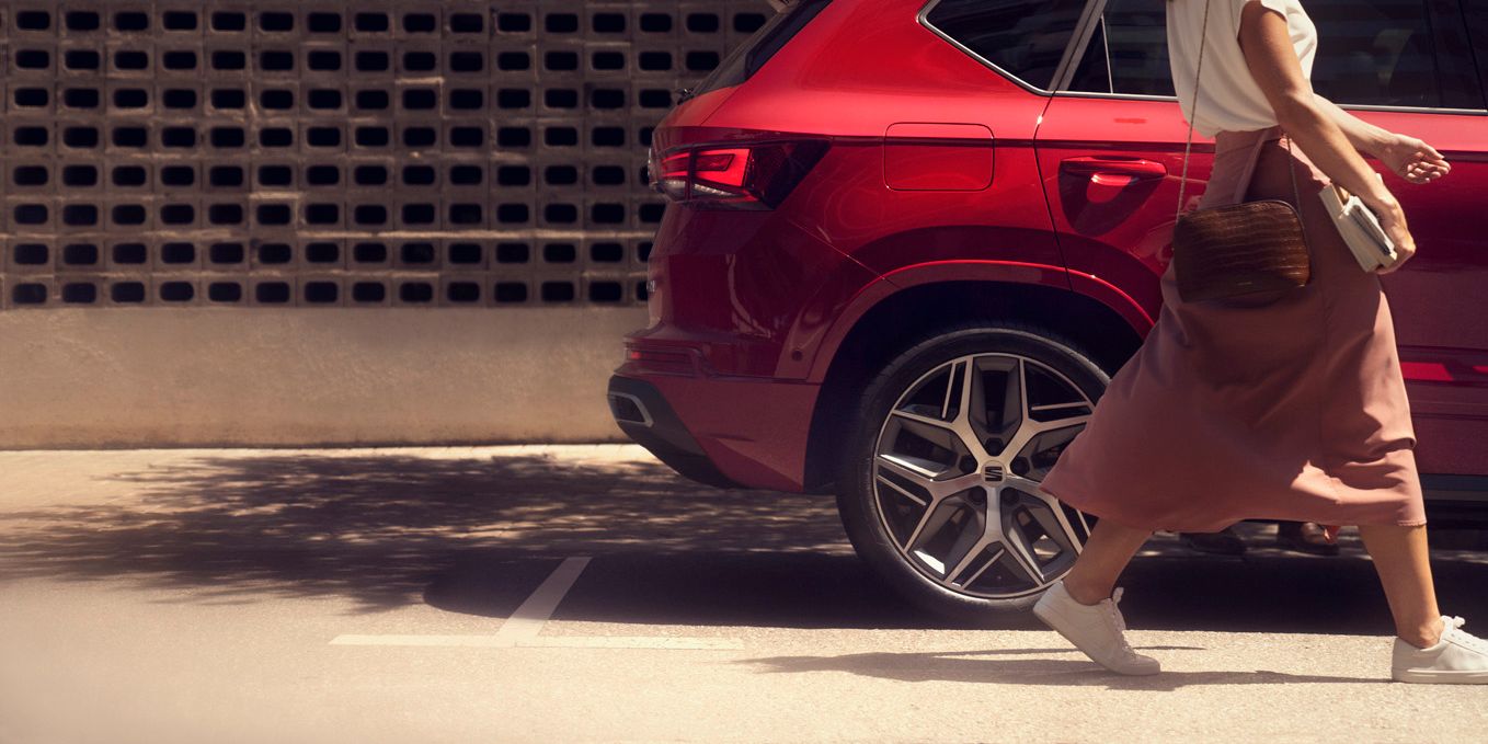 SEAT Ateca mellett sétál egy nő